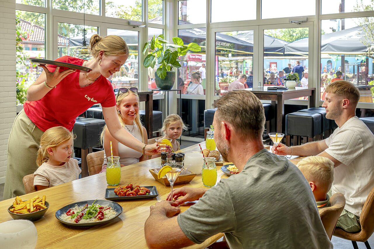 Familia cenando en el restaurante del camping CAPFUN de Wondermolen en Molenschot.
