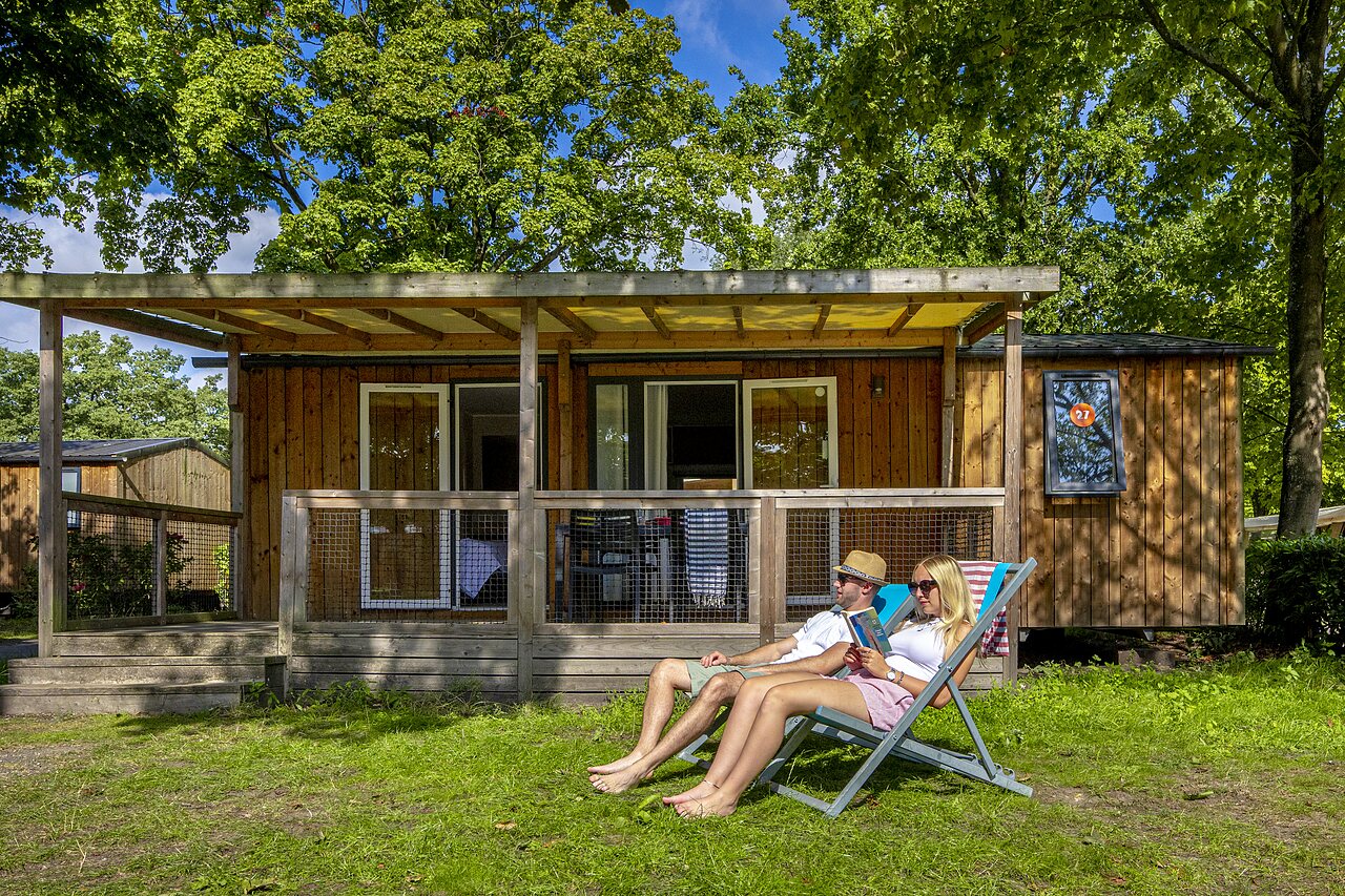 Pareja relaj�ndose frente a mobile home en camping CAPFUN de Wondermolen en Molenschot.