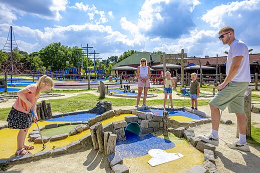 Familia disfrutando del minigolf en el camping CAPFUN de Wondermolen en Molenschot.