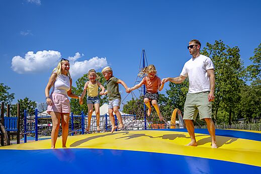 Familia divirtiéndose en el gran cojín hinchable en el camping CAPFUN de Wondermolen en Molenschot.