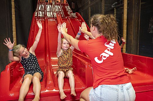 Niños divirtiéndose en el tobogán interior Capfun en Wondermolen, Molenschot.