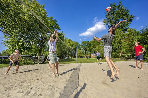 Cancha de voleibol de playa con jugadores en el camping CAPFUN Wondermolen en Molenschot.