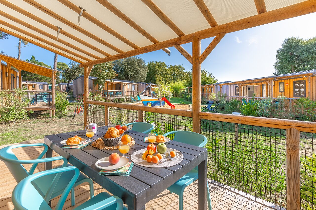 Terraza Mobil-home, desayuno, juegos en camping CAPFUN Zagarella en LONGEVILLE SUR MER (85).