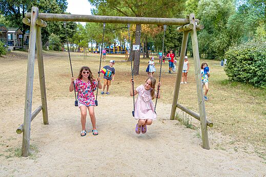Columpio de madera con niños jugando en el camping CAPFUN Zagarella en LONGEVILLE SUR MER (85).