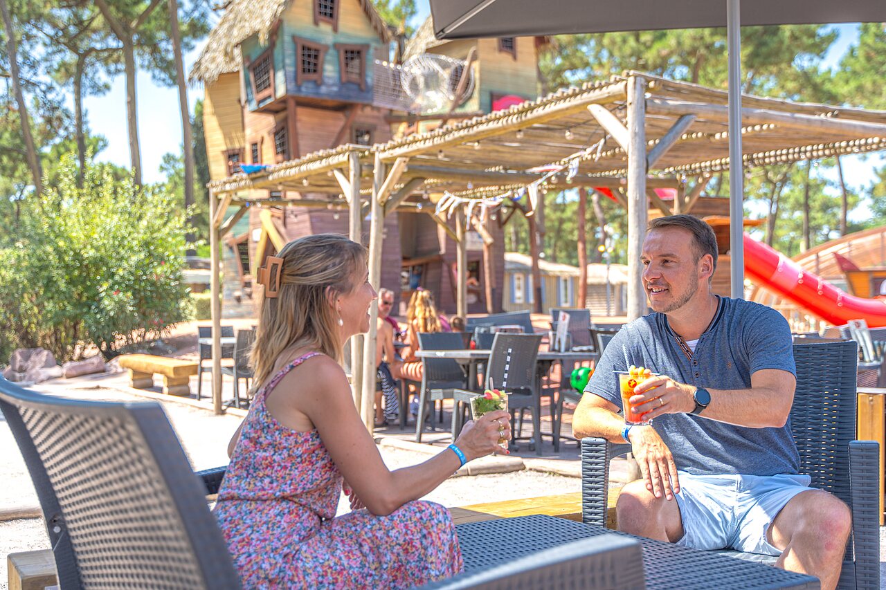 Pareja disfrutando c�cteles en el bar exterior del camping CAPFUN Zephir en Les Mathes La Palmyre (17).