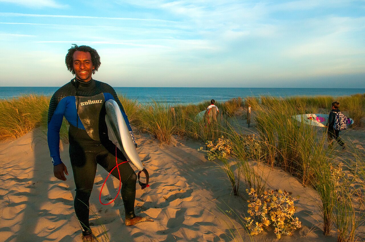 Surfista con tabla de surf en la playa, CAPFUN Zephir, Les Mathes.