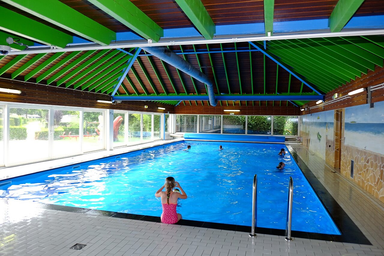 Piscina cubierta con ni�os nadando y jugando en el camping CAPFUN Zeumersehof en Voorthuizen.