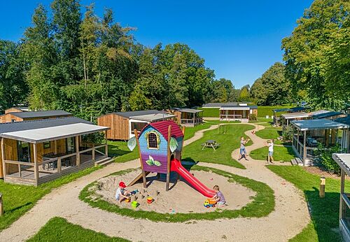 Zona de juegos con tobogán y niños en el camping CAPFUN Zeumersehof en Voorthuizen.