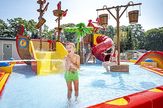 Juegos acuáticos con tobogán y barco pirata en el camping CAPFUN Zeumersehof en Voorthuizen.