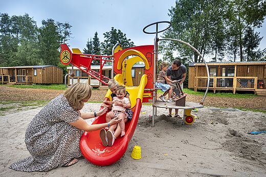 Zona de juegos con tobogán y niños en el camping CAPFUN Zeumersehof en Voorthuizen.